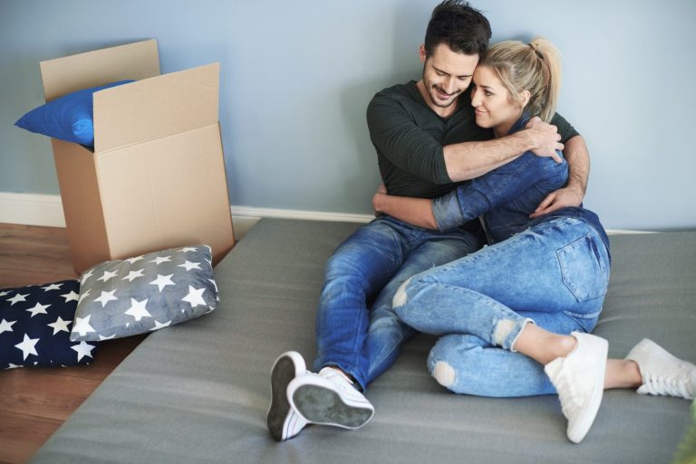 Couple lying down on the floor in their empty house